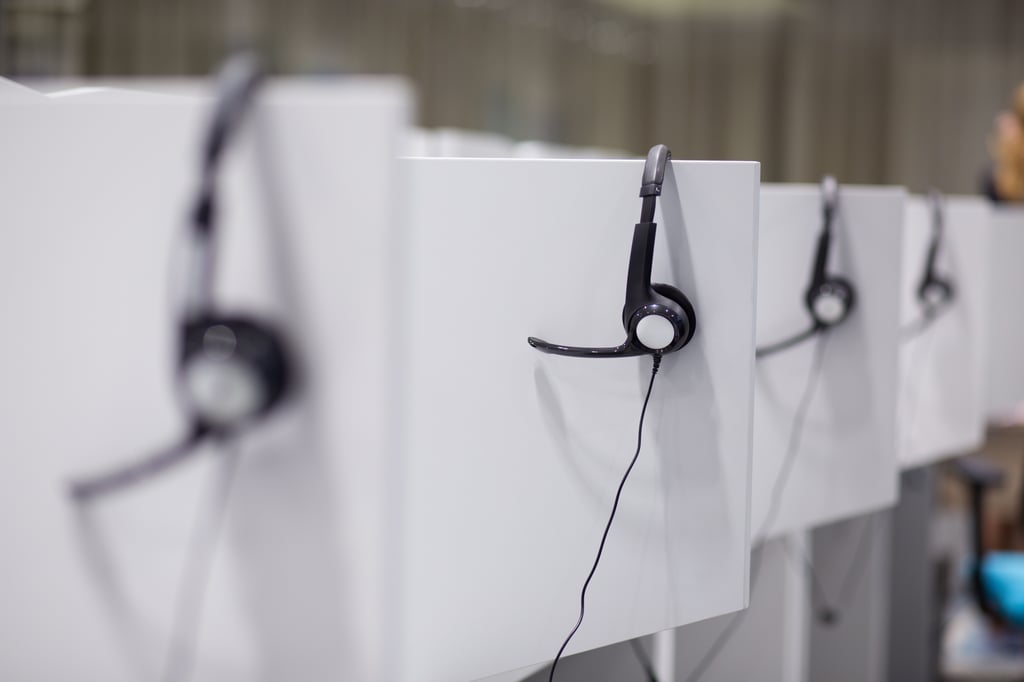headphones-hanging-on-cubicle-partition-in-empty-call-center-office-SBI-322095761